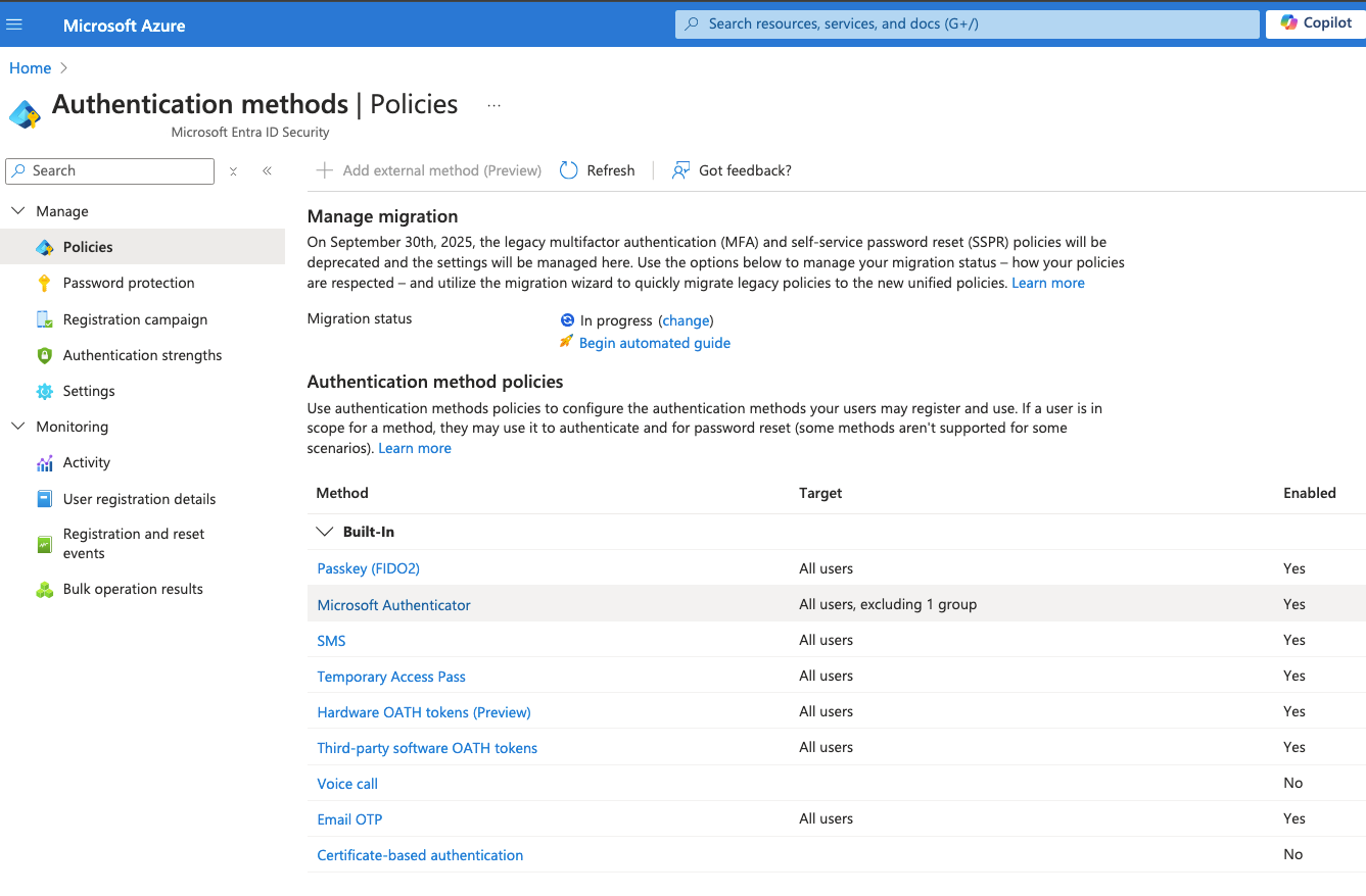 The Authentication methods Policies blade showing the migration status as In progress with the Begin automated guide link, alongside the built-in method policy table.